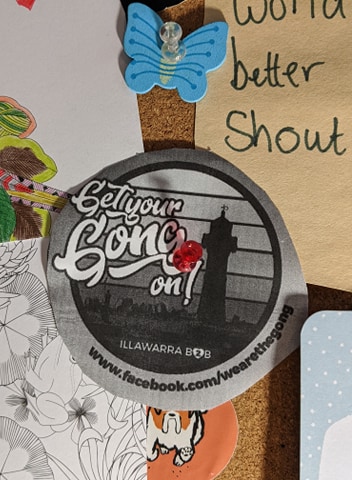 A greyscale version of the Get your Gong on logo is pinned to a noticeboard surrounded by a collage of cards and quotes. Get your Gong on is about bringing Illawarra freelancers and Wollongong businesses together.