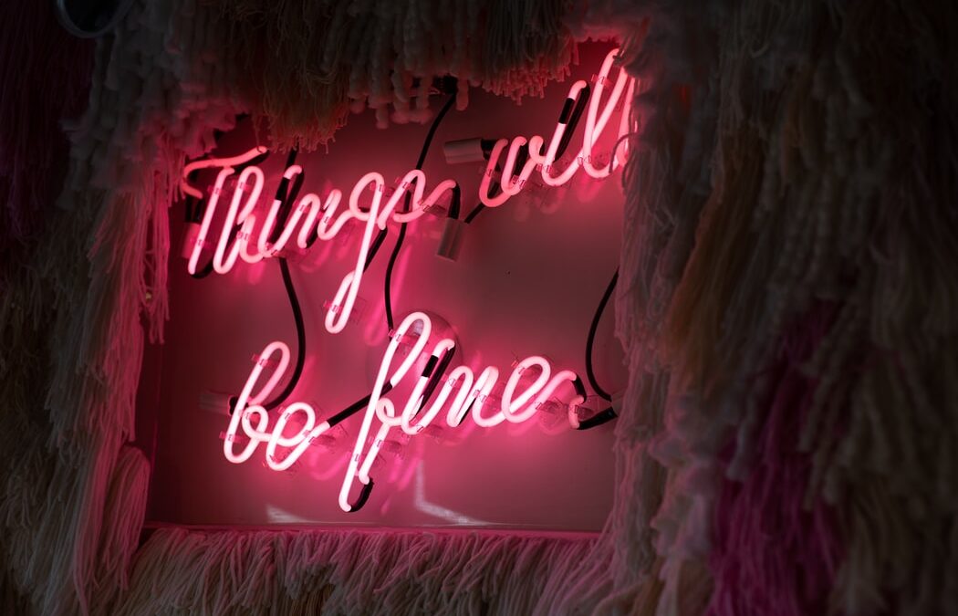 a neon sign reads everything will be fine on a brick wall.