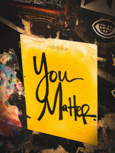 A sheet of yellow lined notepaper with the words "you matter" written in large bold black handwriting.