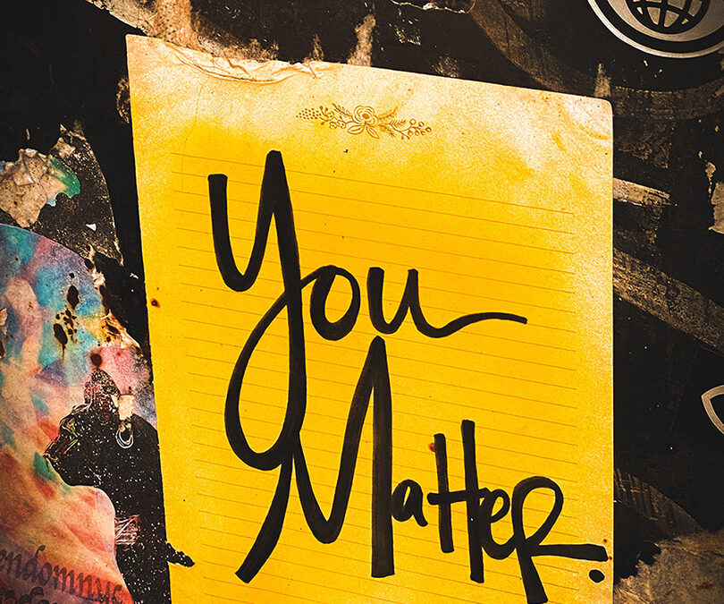 A yellow sheet of note paper with the words "you matter" written in bold black handwriting.