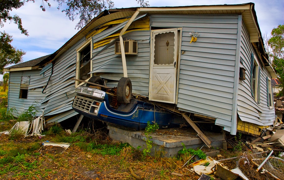a car is under a house after a storm in New Orleans.