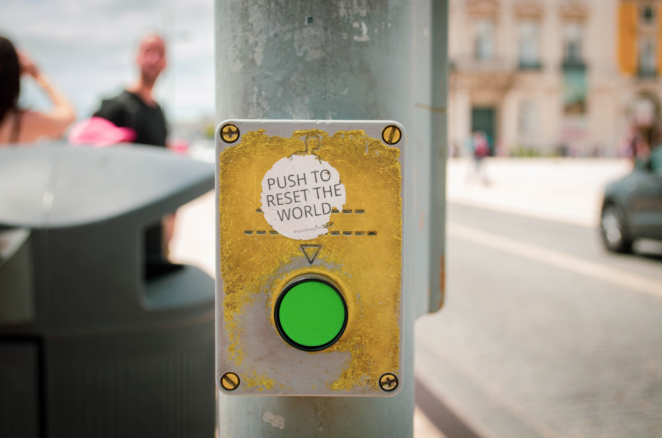 A walk signal has been street art jacked to create a button to reset the world. Which we need when scaling down in freelancing.