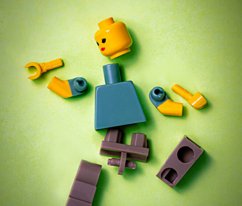 a lego robot is pulled apart in all directions to signify freelancer overwhelm