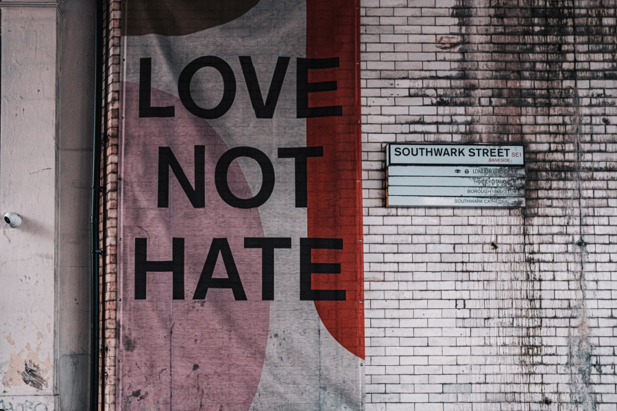 a graffiti wall with a paste up that reads love not hate.