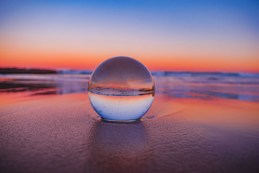 a crystal ball at a beach looks at the dawn to represent 2024 freelance predictions.