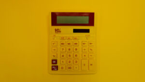 a calculator on a table under a yellow wash.