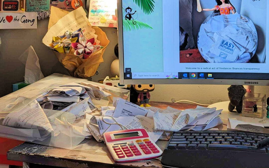 a freelancers desk is covered in receipts as they try to meet the quarterly accounting scramble.